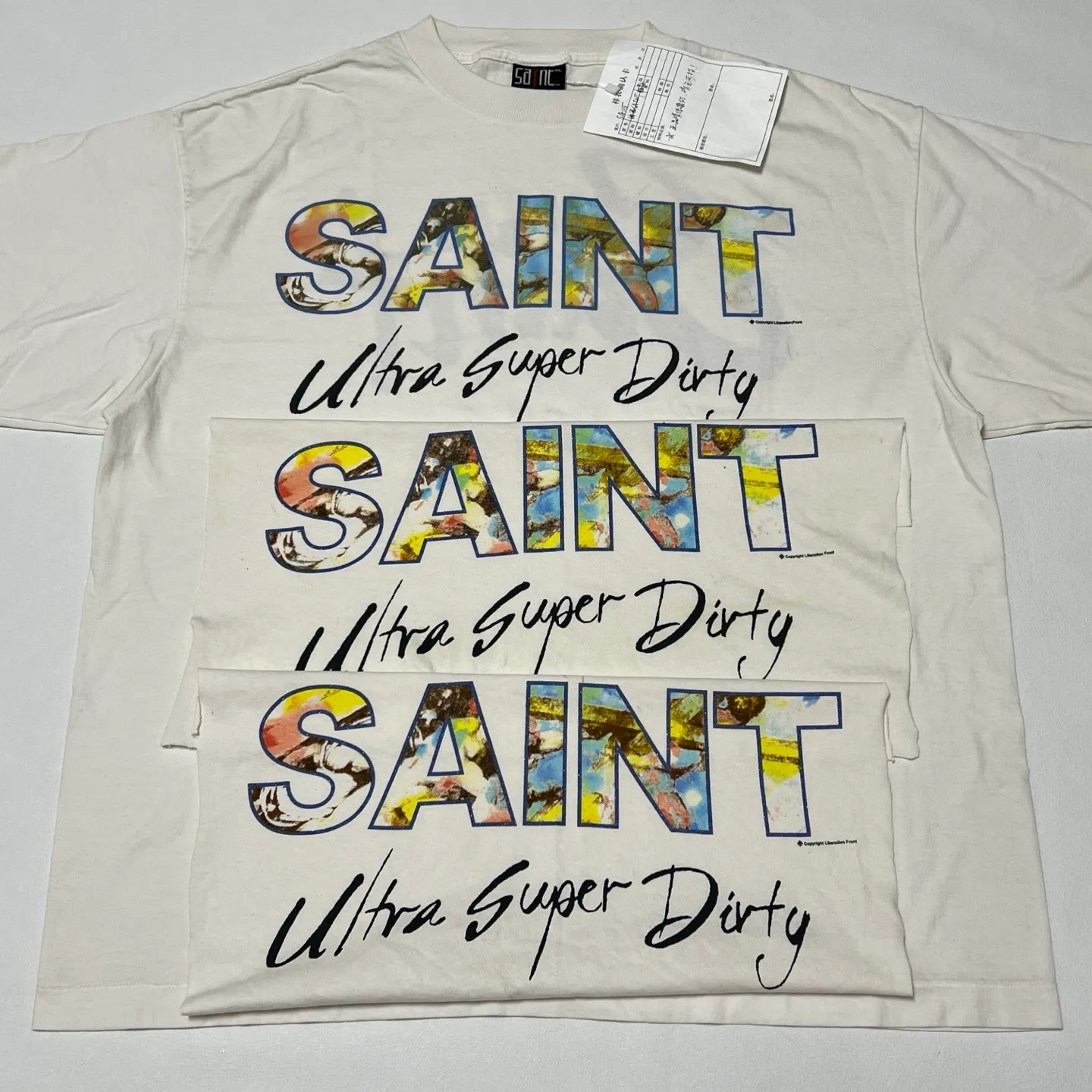 SAINT Mxxxxxx SS TEE/SUPER DIRTY/WHT oil painting SAINT SUPER DIRTY slogan TEE off-white S-XL Made of original OE yarn tube weaving without side seams to distinguish the split fabrics original consistent VINTAGE label/little angel anti-counterfeiting label top printing technology highly restored original details